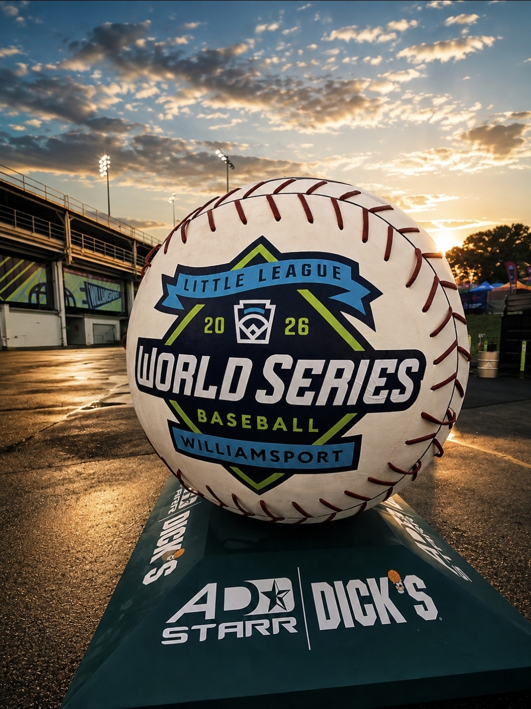 Large decorative baseball displays Little League World Series 2026 Baseball Williamsport at sunset, featuring sponsor logos, Arena Club, and The National Sports Collectors Convention branding nearby.